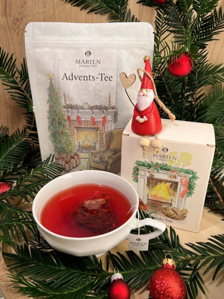 MARIENマリエンのクリスマススペシャルブレンド。温かな暖炉柄の袋タイプとBOXタイプ。白いティーカップにはルビー色のハーブティー。