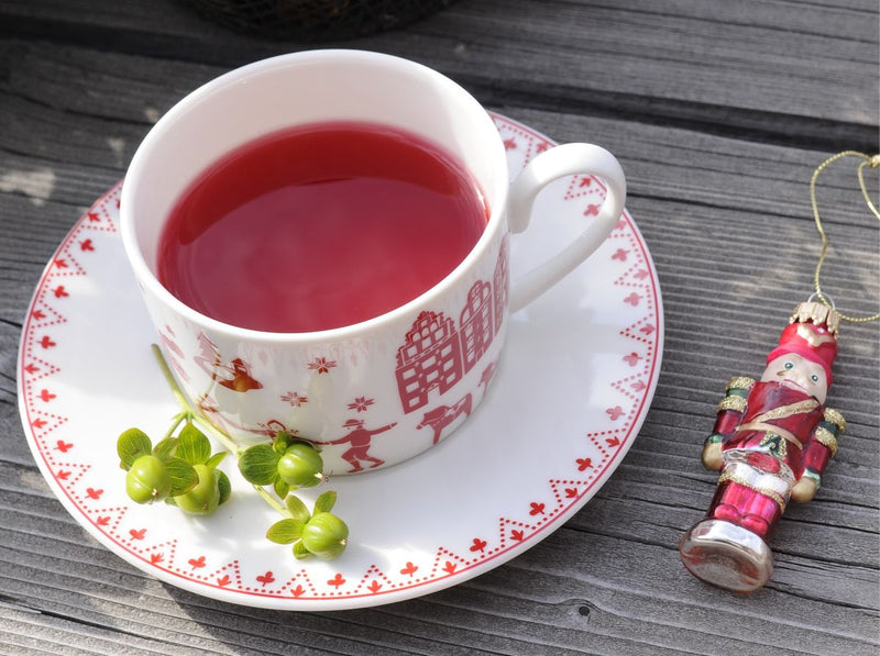 MARIENマリエンのクリスマススペシャルブレンド。屋外のテーブルにはクリスマス柄のティーカップにはルビー色のハーブティー。